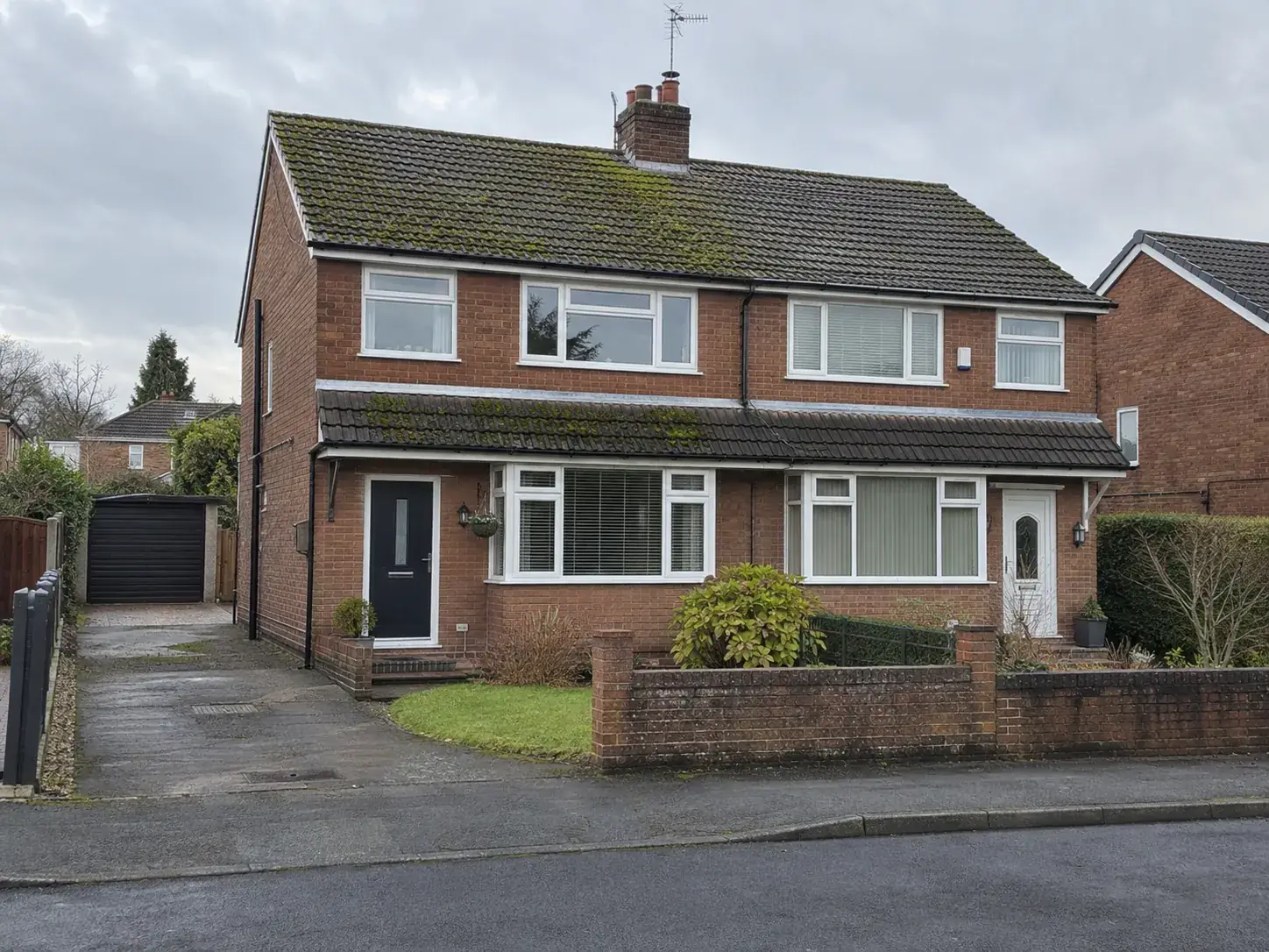Moss-covered roof on a semi-detached house, before and after cleaning, before